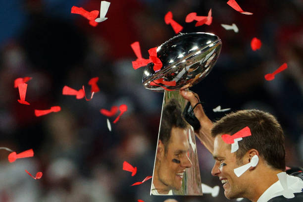 TAMPA, FLORIDA - FEBRUARY 07: Tom Brady #12 of the Tampa Bay Buccaneers celebrates as he is reflected in the Lombardi Trophy after defeating the Kansas City Chiefs in Super Bowl LV at Raymond James Stadium on February 07, 2021 in Tampa, Florida. The Buccaneers defeated the Chiefs, 31-9. (Photo by Patrick Smith/Getty Images)